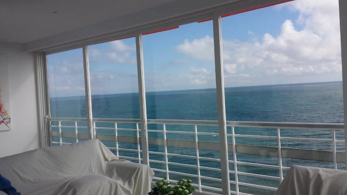 Salón con cerramiento de cristal y vistas al mar